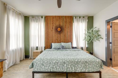 ein Schlafzimmer mit einem Bett mit einer grünen Bettdecke in der Unterkunft Cozy Arabi Home with Yard about 6 Mi to French Quarter! in Arabi
