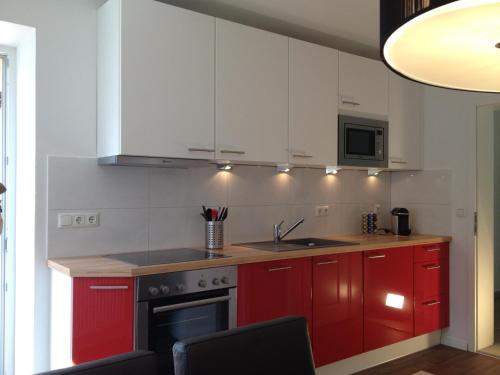 a kitchen with red cabinets and a stove at Haus Irlinger in Schönau am Königssee