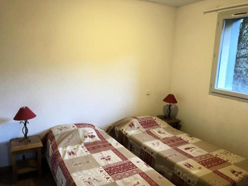 1 Schlafzimmer mit 2 Betten, 2 Lampen und einem Fenster in der Unterkunft Résidence Hameau De Balestas Mp - 3 Pièces pour 6 Personnes 171 in Germ