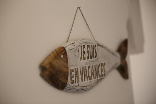 a fish ornament is hanging on a wall at Villa Joséphine 4-11 personnes in Asnelles