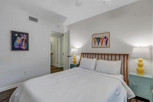 a bedroom with a large white bed with a wooden headboard at Amazing 1 BR apt - 1 block from Jax Beach! in Jacksonville Beach