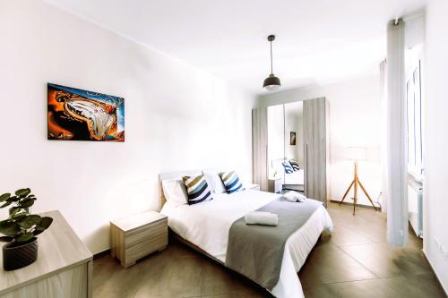 een witte slaapkamer met een bed en een tafel bij Hostly-Family Home Ardenza-Near the seaside in Livorno