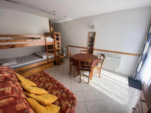 a bedroom with bunk beds and a table and chairs at Résidence Neouvielle - Studio dans le centre de Barèges proche du jardin MAE-5411 in Barèges