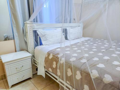 - une chambre avec un lit à baldaquin et une table de chevet dans l'établissement Luxury Suites, à Seeta