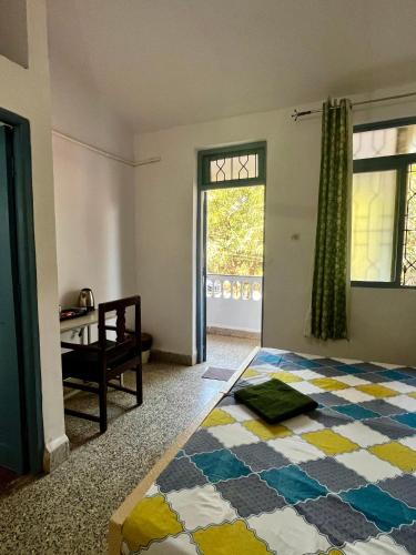 a bedroom with a large bed and a window at Shenvi Homestay in Panaji