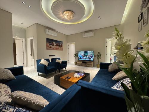 شقة ارضية ٣ غرف نوم وصالة ١ في الرياض: غرفة معيشة مع أريكة زرقاء وطاولة