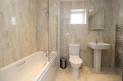 y baño con aseo, lavabo y ducha. en Remarkable 3-Bed House in Bedford en Bedford