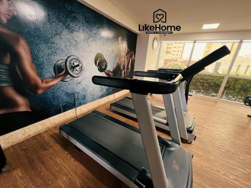 a gym with a wall mural of a man lifting weights at Tambaú Flex Home - LikeHome in Tambaú