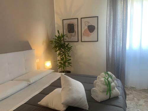 um quarto com uma cama com almofadas e uma planta em b&b Calvino em Piacenza