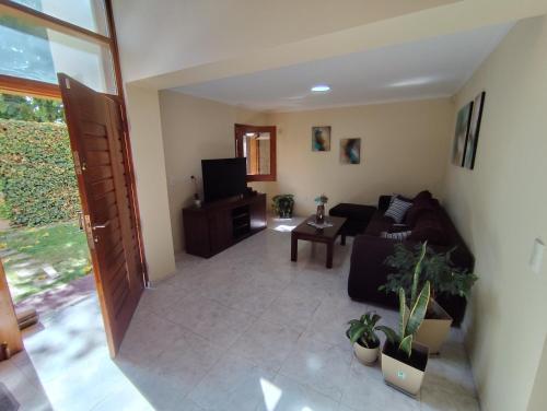 a living room with a couch and a tv at Chacras de Coria Los Robles in Chacras de Coria