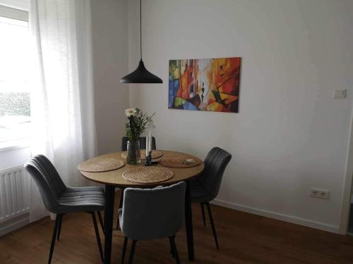 uma mesa de jantar com cadeiras e um quadro na parede em Central stylish apartment em Braunau am Inn