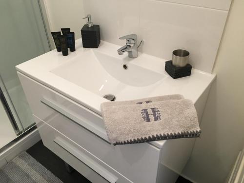 un lavabo de salle de bain blanc avec une serviette dessus dans l'établissement Grand Studio design avec parking, à Neuilly-sur-Seine