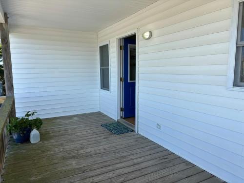 a front door of a house with a blue door at Clamelot in Holden Beach