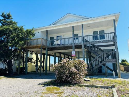 a house with a large deck on the side of it at Clamelot in Holden Beach