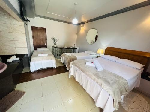 een hotelkamer met 2 bedden en een wastafel bij POUSADA BELLA CANASTRA in Piuí