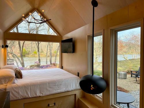 a bedroom with a window in a tiny house at Asheville River Cabins in Arden