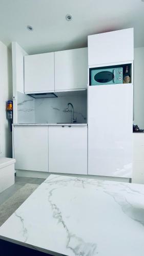 La cuisine blanche est équipée d'un évier et d'un réfrigérateur. dans l'établissement Tiny House with Sea View, à Roquebrune-Cap-Martin