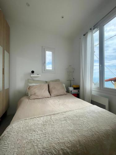 une chambre avec un grand lit et une fenêtre dans l'établissement Tiny House with Sea View, à Roquebrune-Cap-Martin