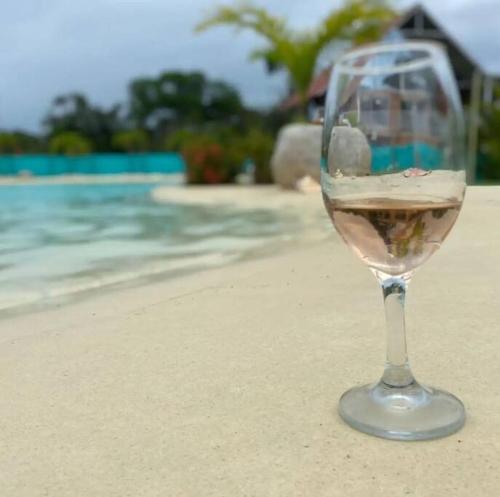 een glas wijn zittend op een strand bij COVEÑITAS MC1P1B Cabaña con piscina tipo playa in Melgar