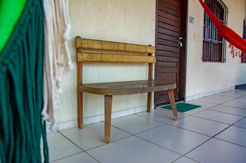 a wooden bench sitting on a tile floor next to a door at Pousada Flat Castor in Natal