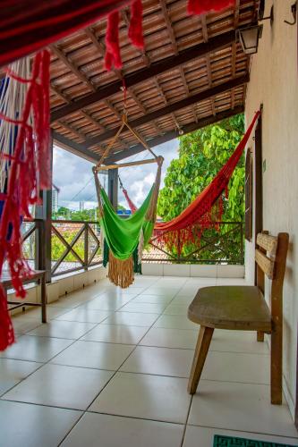 a hammock on the porch of a house at Pousada Flat Castor in Natal