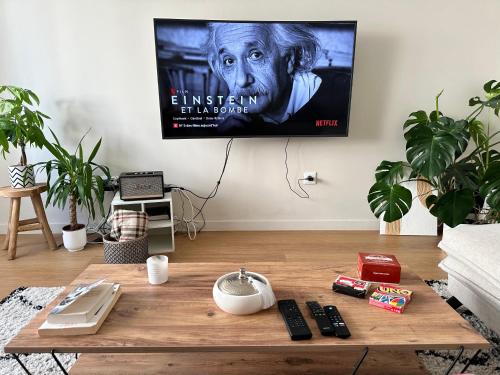 - un salon avec une télévision et une table basse en bois dans l'établissement Logement bien équipé près de Paris et stade de France avec place de stationnement, à Sannois