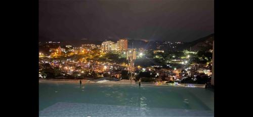 a view of a city at night with a swimming pool at Santa Lucia Lofts Duplex in Cali