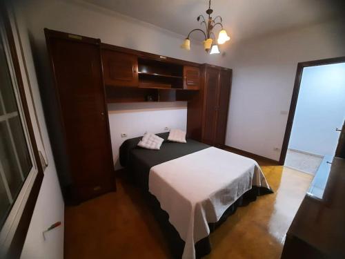a bedroom with a bed in a room with a chandelier at Fogar dos Petellos, Mondariz. in Mondariz