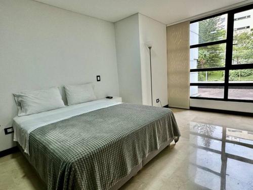 um quarto com uma cama grande e uma janela grande em 302 Spacious apartment nice view in El Poblado em Medellín