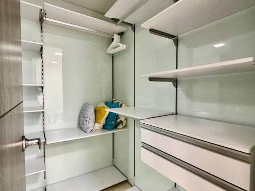Elle comprend un dressing avec des comptoirs et des étagères blancs. dans l'établissement 302 Spacious apartment nice view in El Poblado, à Medellín
