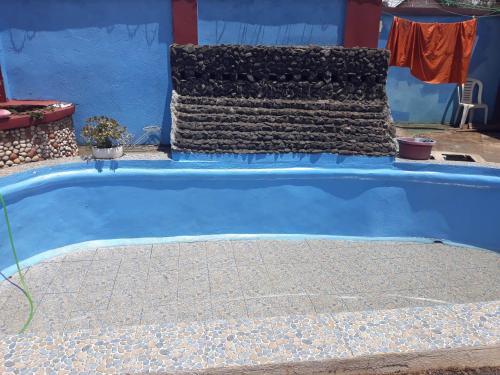 ein Pool in einem blauen Haus mit blauer Wand in der Unterkunft Villa Caroline in Antsirabe