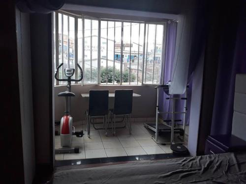 une chambre avec deux chaises et une grande fenêtre dans l'établissement Villa Caroline, à Antsirabe