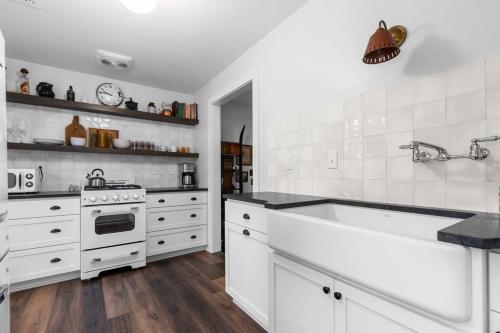a white kitchen with a sink and a stove at Hickory Hideaway, Cozy 2 bedroom with private dock in Oshkosh
