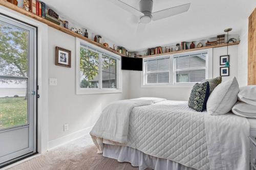 een slaapkamer met een bed in een kamer met ramen bij Hickory Hideaway- Dock on Lake Winnebago in Oshkosh
