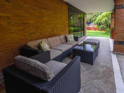 a patio with a couch and chairs and a table at Quinta La Paloma in Itauguá