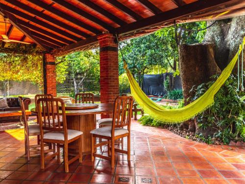 a patio with a hammock and a table and chairs at Quinta La Paloma in Itauguá
