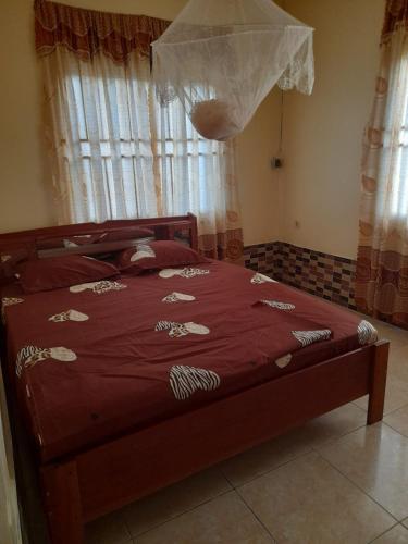 a bedroom with a bed with a red comforter at Kapowlito Real Estate Casa Sitalweg in Paramaribo