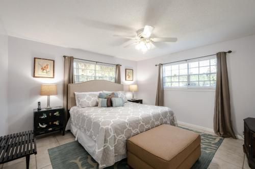 una camera da letto con un letto e un ventilatore a soffitto di The Pearl of Dauphin Island a Dauphin Island