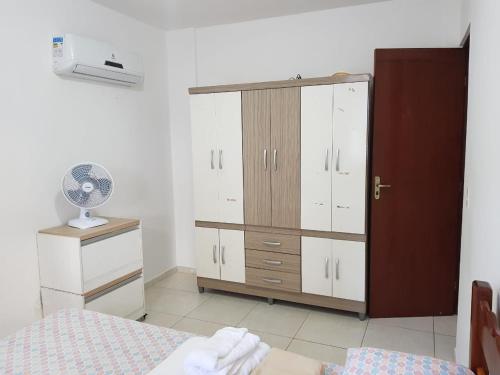 een slaapkamer met een bed, een dressoir en een kast bij Quarto e Sala - 200 M. Praia dos Milionários in Ilhéus