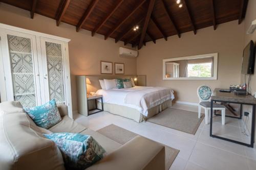 a bedroom with a bed and a couch at Faro Norte Suites in Asunción