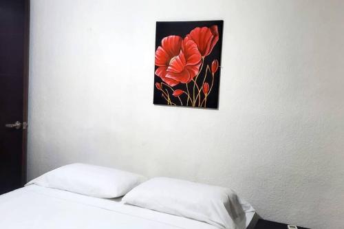 a picture of a flower on the wall above a bed at Zely home # 4 in Cancún