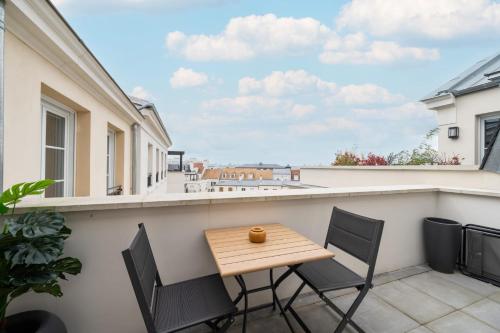 d'une terrasse avec une table et des chaises en bois sur un balcon. dans l'établissement Appartement Fransokyo - Welkeys, à Serris