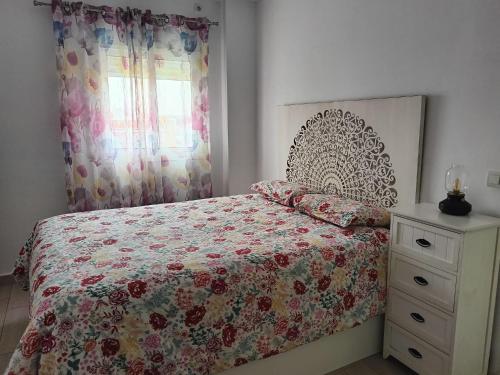 um quarto com uma cama, uma cómoda e uma janela em Piso luminoso y acogedor em Alcalá de Guadaira