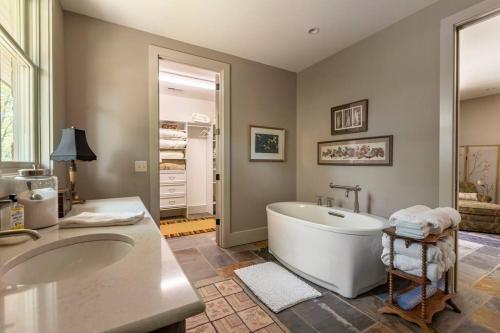 een badkamer met een groot bad en 2 wastafels bij The Poet's House, Luxury and Solitude on 100 acres in Lewisville