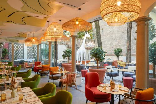 a restaurant with tables and chairs and a giraffe on the wall at Hotel Indigo Florence, an IHG Hotel in Florence
