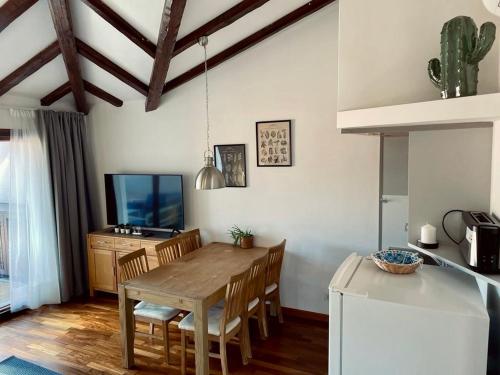 cocina y comedor con mesa y TV en Apartment Flavia, en Muggia