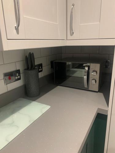 a kitchen counter with a microwave in a kitchen at Ty Haf in Aberdare