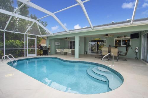 a swimming pool in the middle of a house at Tropical Breeze Canal Waterfront Home, Heated Pool in Cape Coral