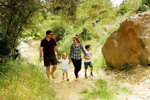 a family is walking down a dirt path at Ca La Pia in Corbíns