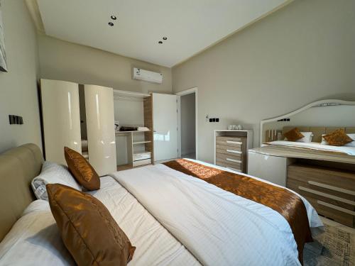 Un dormitorio con una cama grande con almohadas. en شقة فاخرة غرفة وصالة بالعارض ٢ en Riad